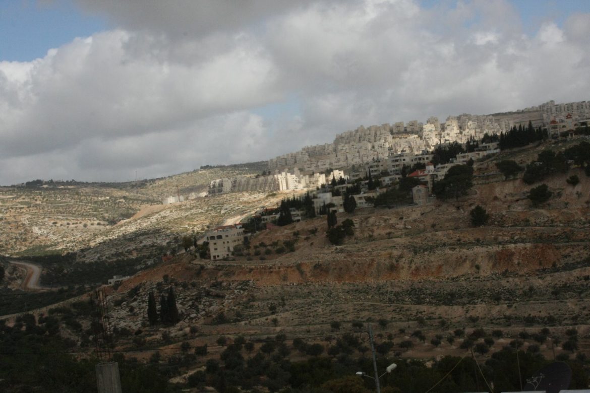 Image of buildings on hillside, half in shadow