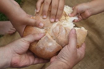 Hands breaking bread