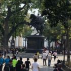 people standing in plaza staring at statue