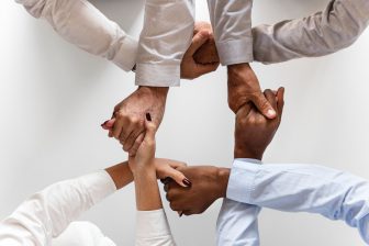 4 pairs of hands clasped in a circle