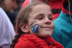 Girl's face with "Earth First" painted on her cheek