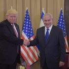 Trump and Netanyahu shaking hands in front of American and Israeli flags